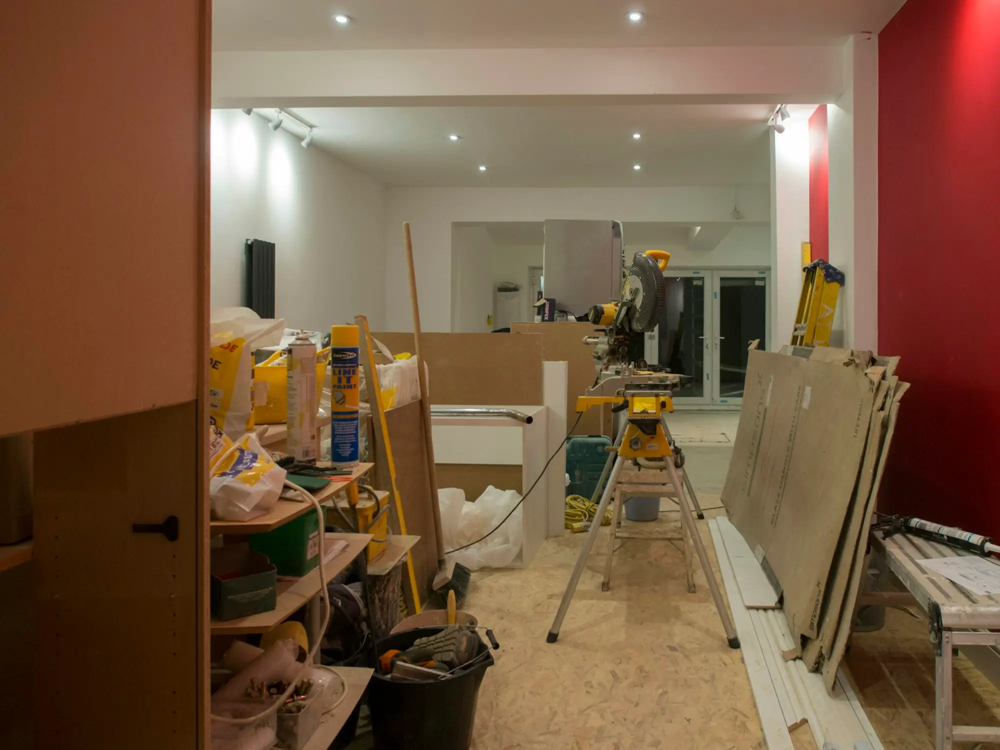 A shop interior mid fit-out with trestles, building materials and freshly painted walls.